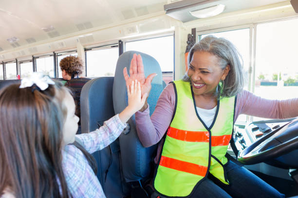 Female driver high-fives student boarding school bus