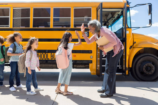 el niño da al conductor del autobús escolar un alto-cinco - niño pre escolar fotografías e imágenes de stock