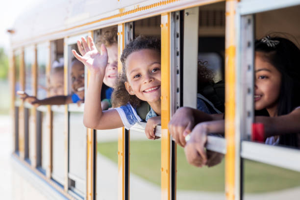 istock Young schoolgirl smiles at camera and waves 1152656422