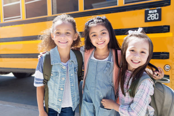 istock Three schoolgirls hug and look at the camera 1152656428