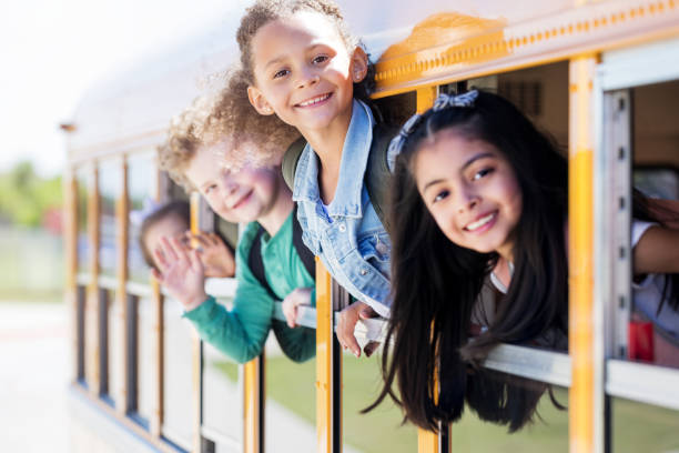 istock Children lean out of school bus windows 1152656429