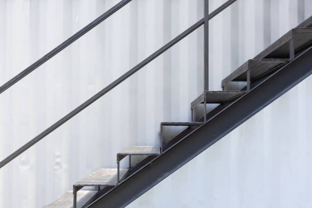 istock outside metal staircase or fire exit stair with sheet corrugated wall background. 1152656450