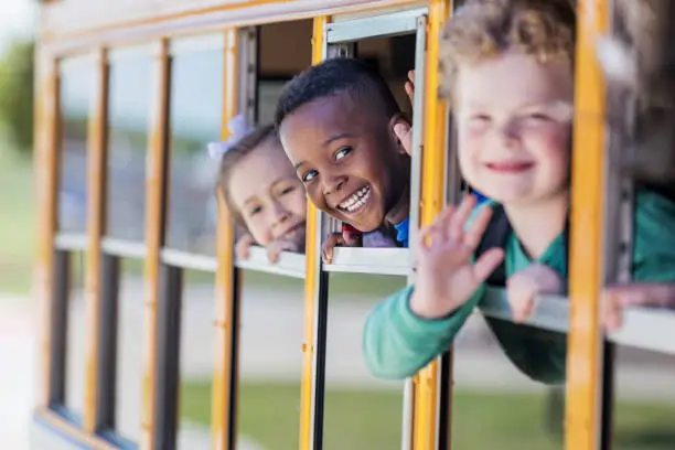 Photo of Schoolboy leans out of school bus window