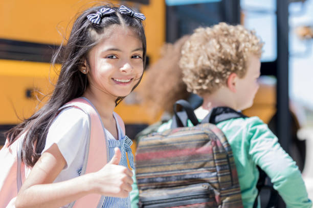 istock Confident elementary schoolgirl gives thumbs up to camera 1152656486