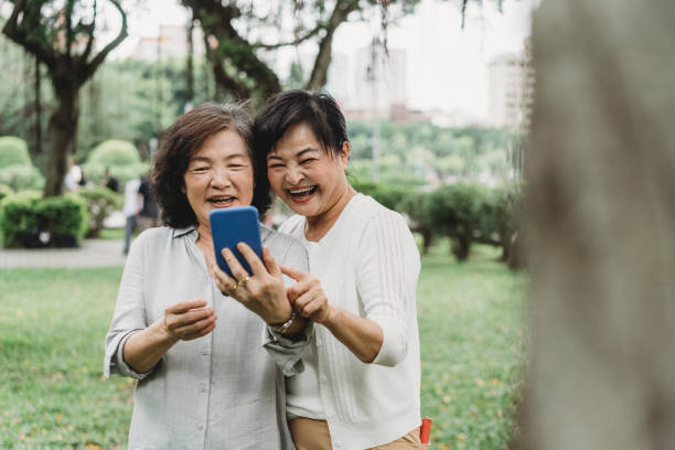 istock Two senior ladies using a mobile phone together at the park 1152656901