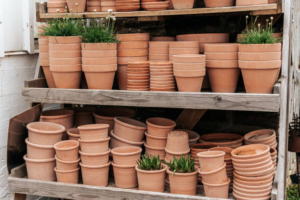Terracotta clay pots for garden plants and flowers. Decorative flower pots and vases outside. Flower business stock photo
