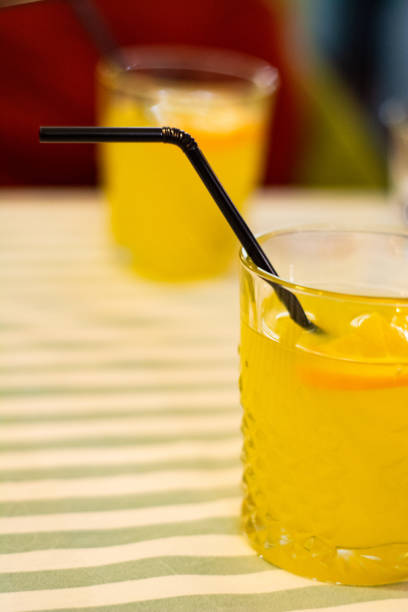 istock Two glasses with orange lemonade on the table in a cafe. 1152661334