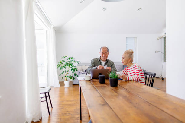 feliz pareja senior usando laptop en casa - senior couple audio fotografías e imágenes de stock