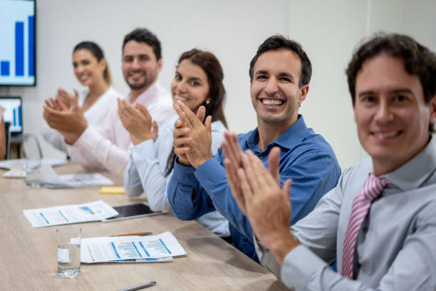 istock Adult business team celebrating applauding while facing camera smiling 1152667941