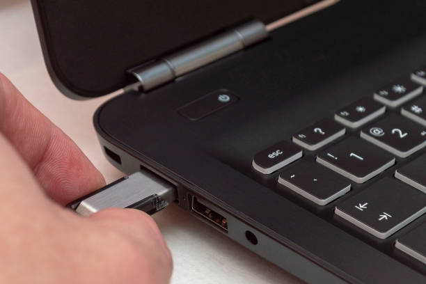 istock A man holds up a flash drive from the port on your laptop. 1152668043
