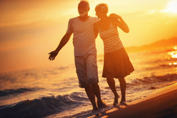 istock Senior couple walking on the beac at sunset. 1152672779