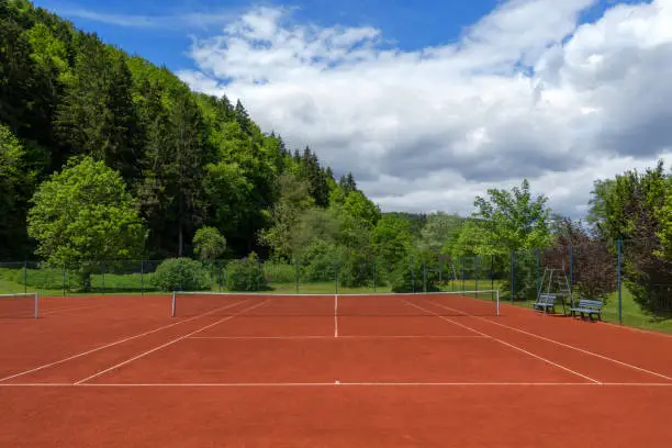 Clean pulled tennis court with red sand after the spring overhaul