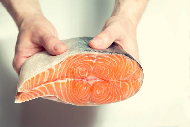 istock Piece salmon fish in male hands. 1152679174