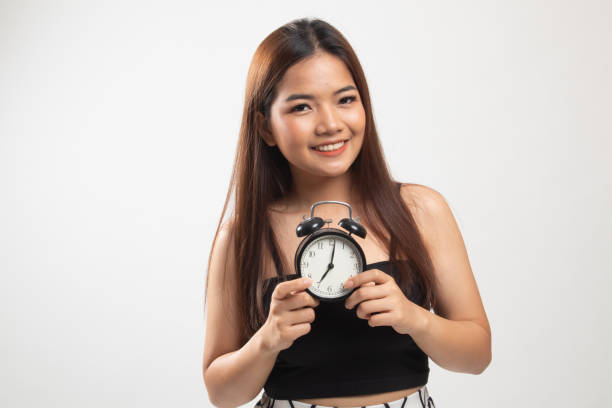 istock Young Asian woman smile with a clock. 1152680630