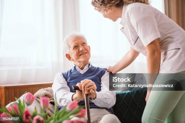 Senior Man With A Walking Stick Being Comforted By Nurse In The Hospice Stock Photo - Download Image Now