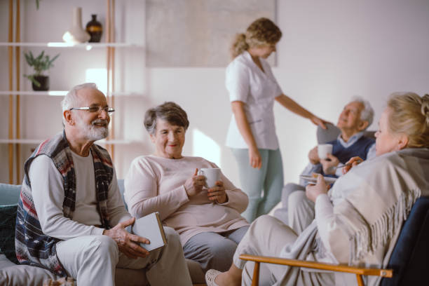 uomo anziano sorridente che parla con altri residenti della casa di riposo - shock grandmother surprise senior adult foto e immagini stock