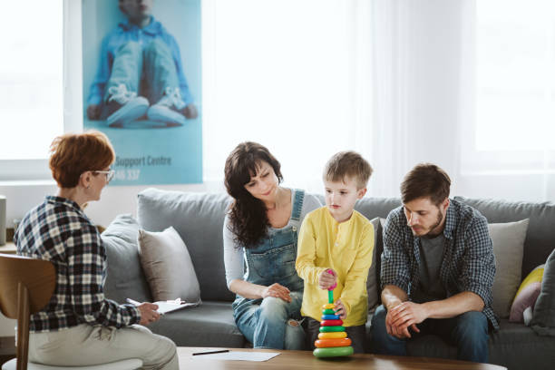 los padres y el terapeuta están sentados en el sofá durante una reunión sobre su hijo - mental illness energy people men fotografías e imágenes de stock