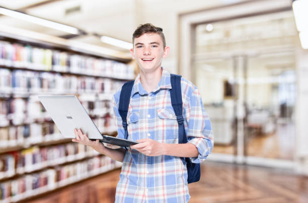 istock 13 year old teenage boy - using laptop 1152682455