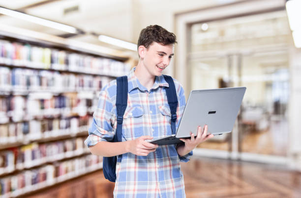 istock 13 year old teenage boy - using laptop 1152682465