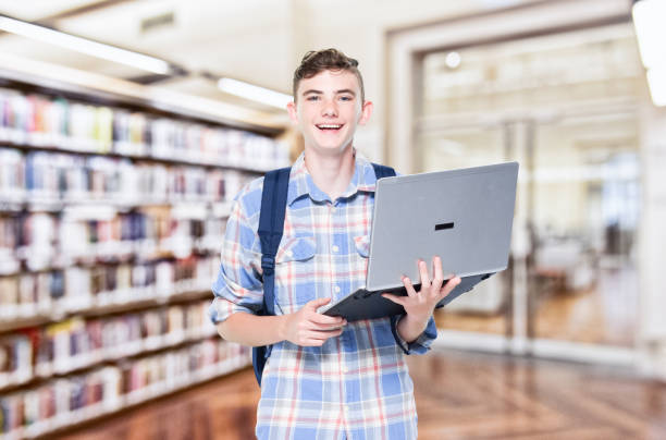 istock 13 year old teenage boy - using laptop 1152682516