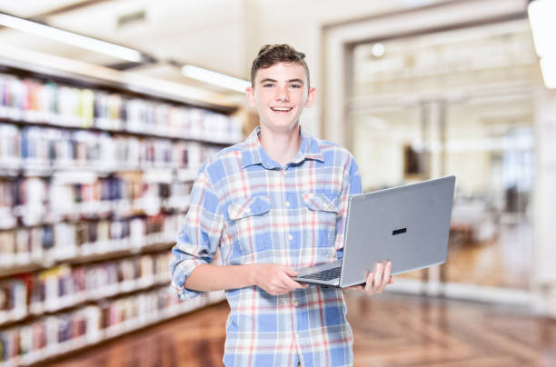 istock 13 year old teenage boy - using laptop 1152682801