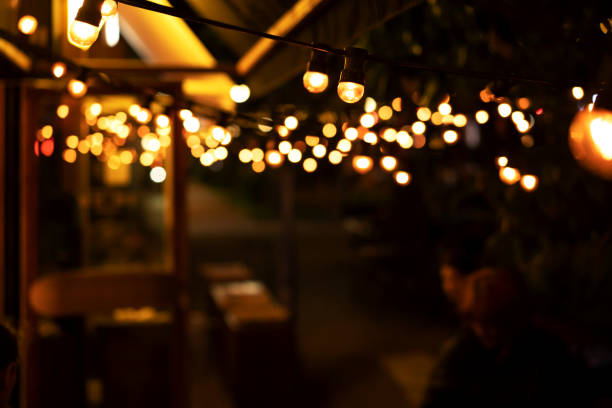 luces borrosas de la cafetería por la noche - fiesta en el jardín fotografías e imágenes de stock