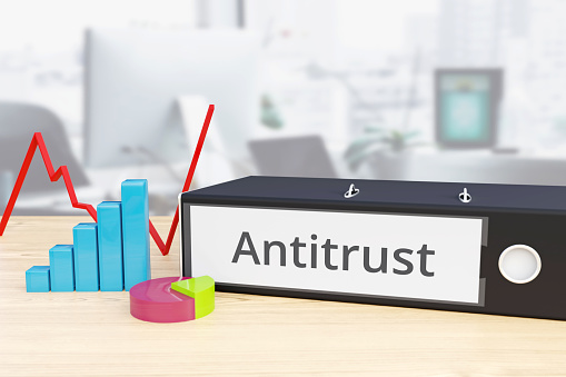 Antitrust - Finance/Economy. Folder on desk with label beside diagrams. Business