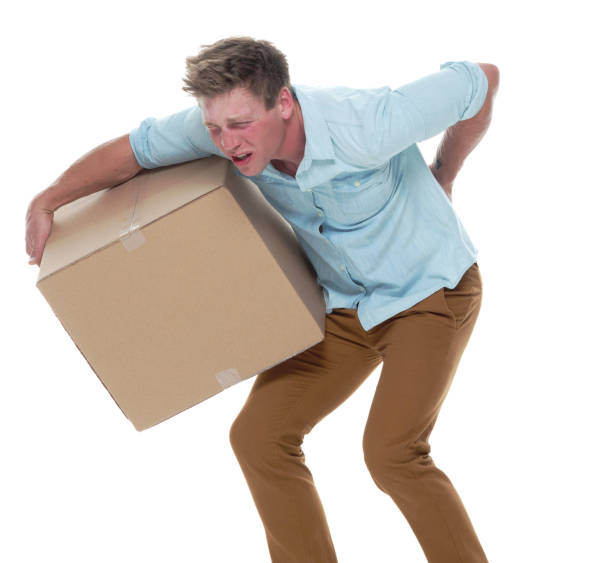 istock Good looking man holding a brown box and has back pain 1152690371