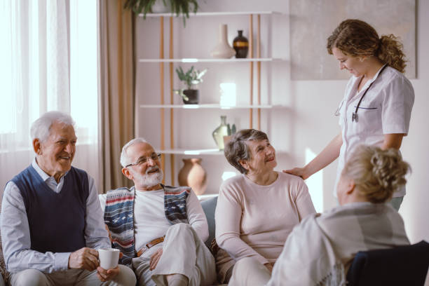 anziani sorridenti che parlano con l'infermiera nella casa di riposo - shock grandmother surprise senior adult foto e immagini stock