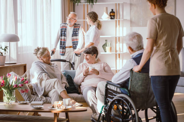 Elderly men and women talking in the common room in nursing home Elderly men and women talking in the common room in nursing home civilian stock pictures, royalty-free photos & images