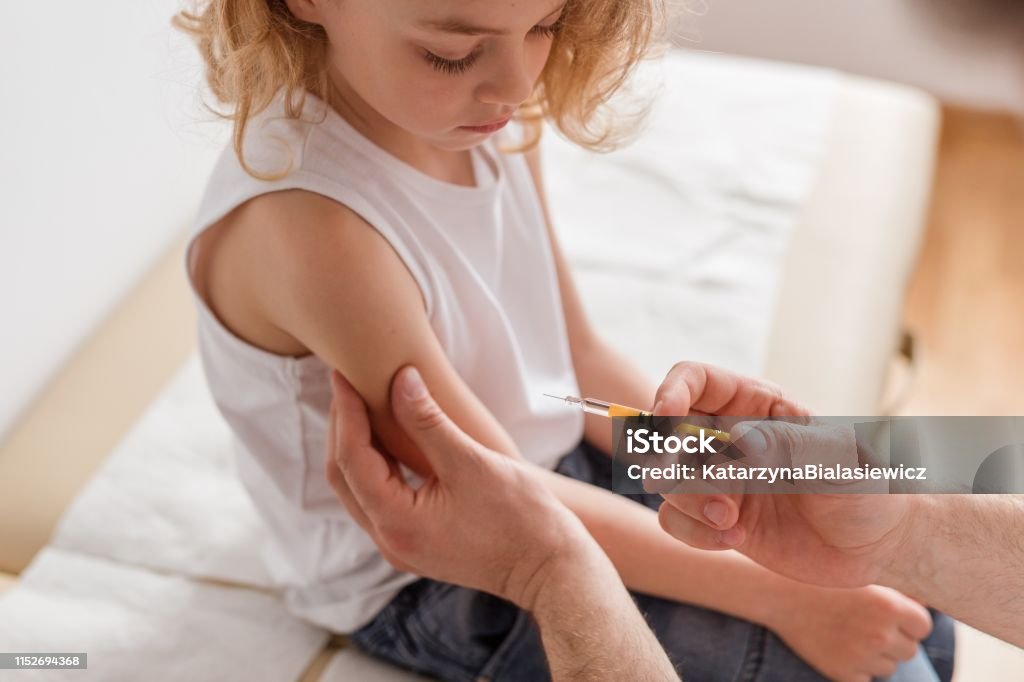 Nahaufnahme eines süßen blonden Jungen und eines Arztes mit einer Spritze - Lizenzfrei Impfung Stock-Foto
