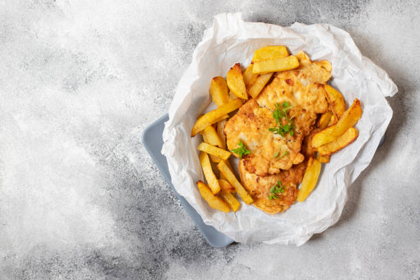 istock Traditional British fish with chips. On a gray plate and gray concrete background. Space for text. Top view, flat lay 1152694754