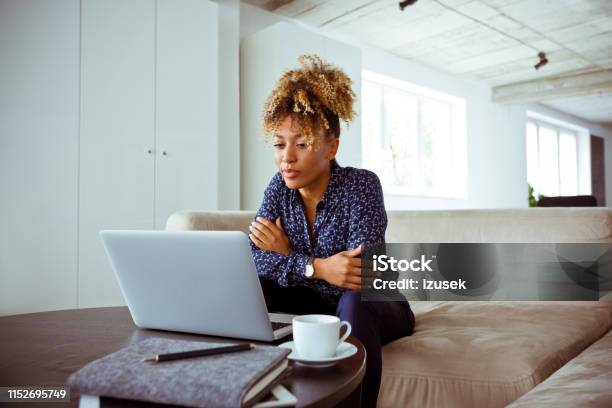 Confident Businesswoman Looking At Laptop Stock Photo - Download Image Now - Corporate Business, 30-34 Years, Adult