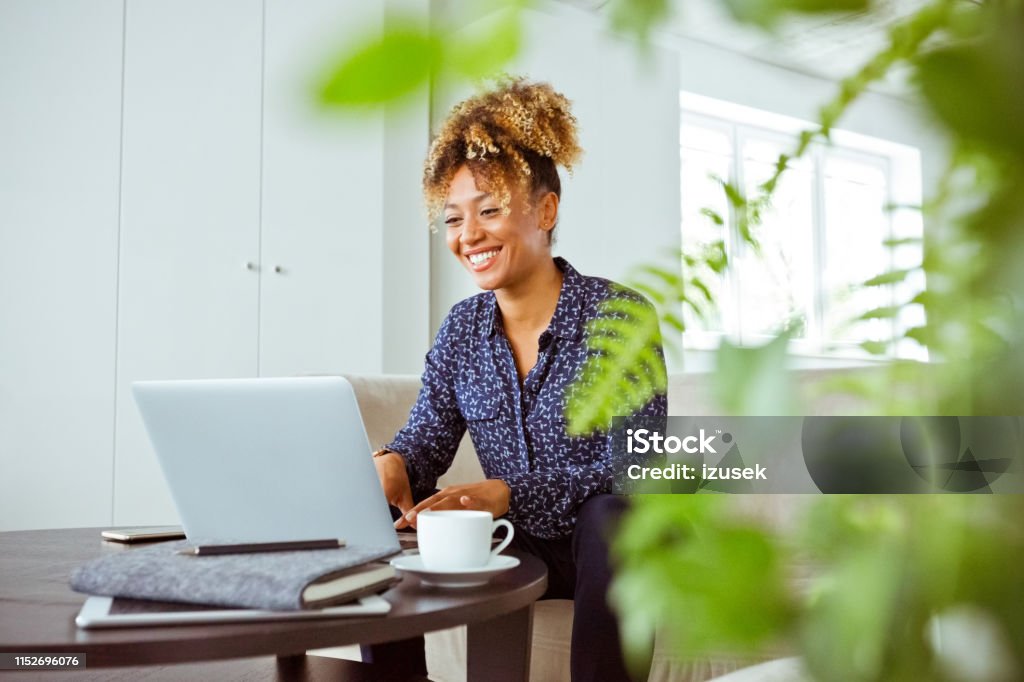 Smiling female financial advisor working in office Smiling financial advisor working in office. Female corporate expert is using laptop. She is with confident look on her face. Financial Advisor Stock Photo