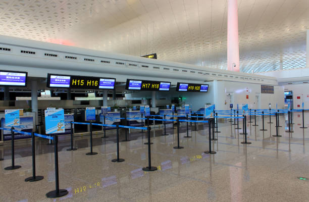 empty check-in counters at the airport - airport arrival departure board airport check in counter airplane imagens e fotografias de stock
