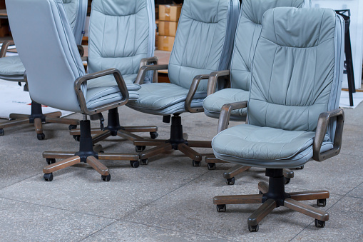 Several gray leather office chairs ready for packaging in a furniture warehouse, online furniture store.