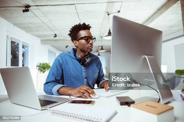 Confident Financial Advisor Using Computer At Desk Stock Photo - Download Image Now - African-American Ethnicity, Laptop, Males