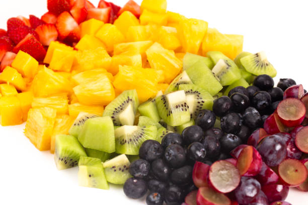 Lines of Rainbow Colored Fruit Isolated on a White Background