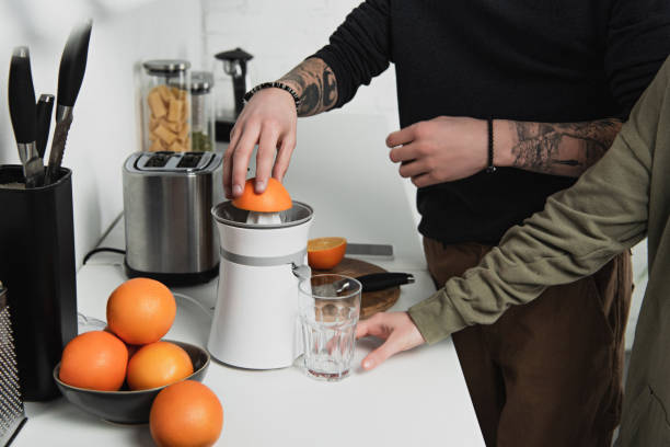 istock partial view of couple preparing orange juice during breakfast in kitchen 1152714531