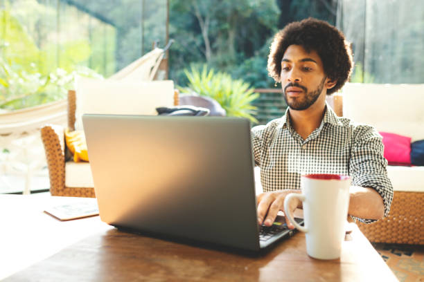 istock Young man using laptop in the living room 1152719044