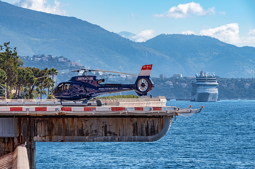 Air traffic at Monaco Heliport, Monaco - May 3, 2019: small blue helicopters shuttle passengers into the city