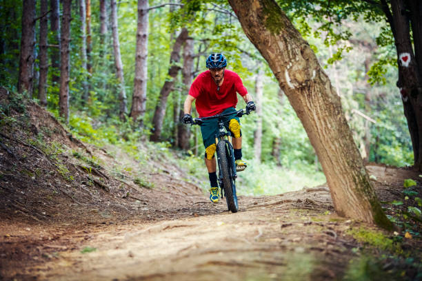istock Mountain biker climbing in the woods 1152724156