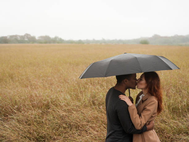 istock Romantic couple kissing under an umbrella 1152725324