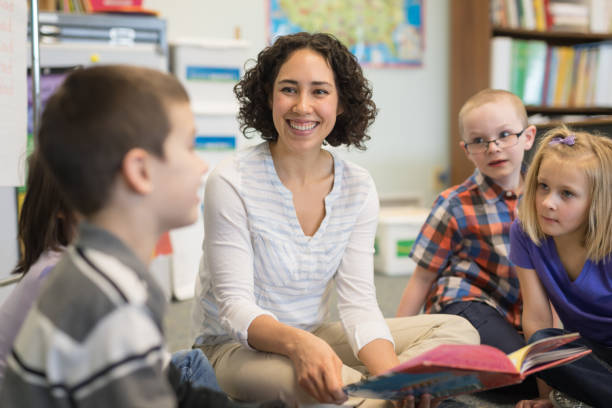 istock Female teacher reading to her first grade students 1152726133