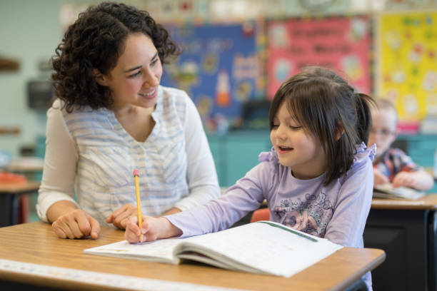 istock First grade girl talking with her teacher in the classroom 1152726165