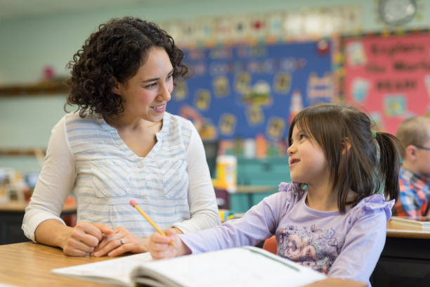 istock Teacher helping a first grade girl in the classroom 1152726166