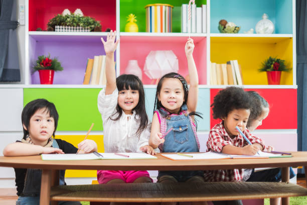 istock Group diversity kids studying at school, rising hands for answer and question in classroom, kids education concept 1152740787