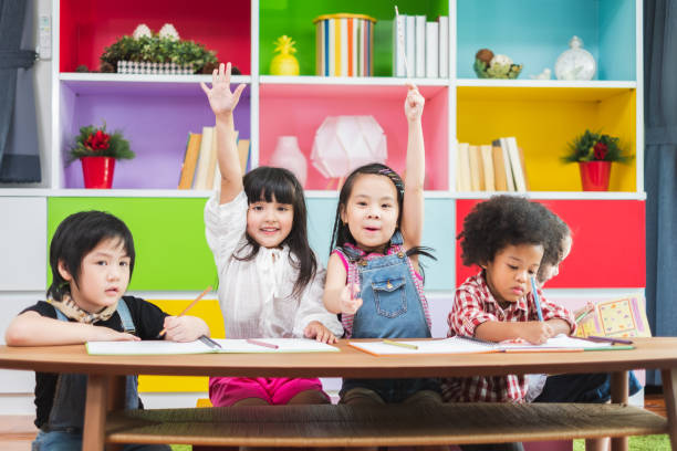 istock Group diversity kids studying at school, rising hands for answer and question in classroom, kids education concept 1152740833