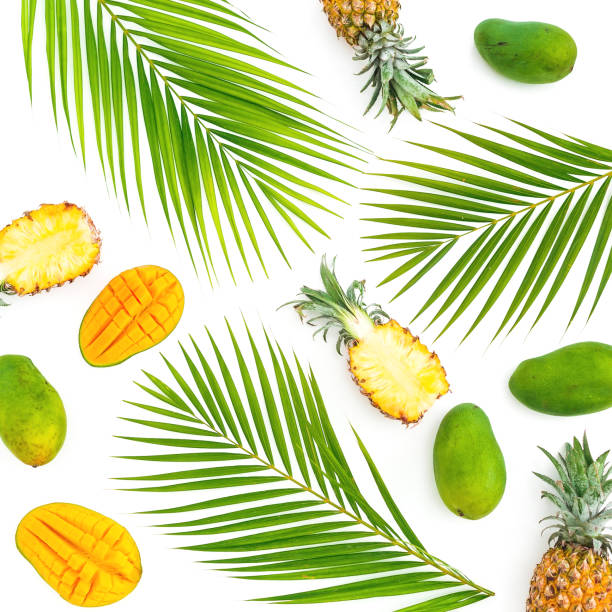 Frame with pineapple, mongo and palm leaves on white background. Flat lay, top view. Tropical concept.