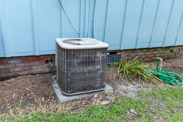 istock Old rusty HVAC Air Conditioner Compressor next to blue house 1152752389